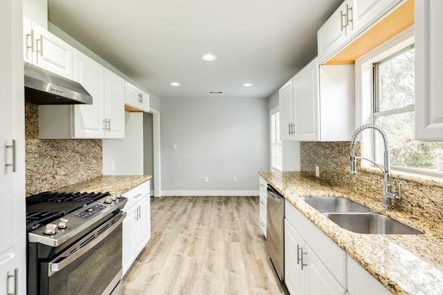 kitchen featuring appliances with stainless steel finishes, white cabinetry, and sink