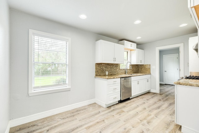 kitchen with dishwasher, white cabinets, light stone counters, and light hardwood / wood-style flooring