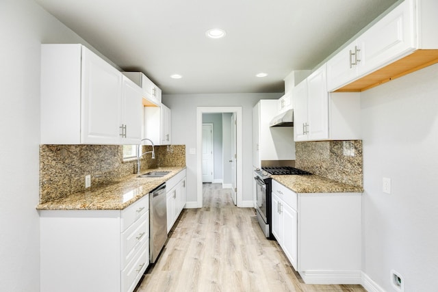 kitchen featuring light stone counters, sink, white cabinetry, and stainless steel appliances