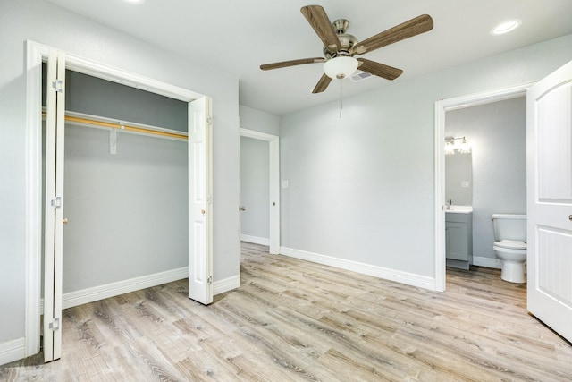 unfurnished bedroom with a closet, light hardwood / wood-style flooring, ceiling fan, and ensuite bathroom