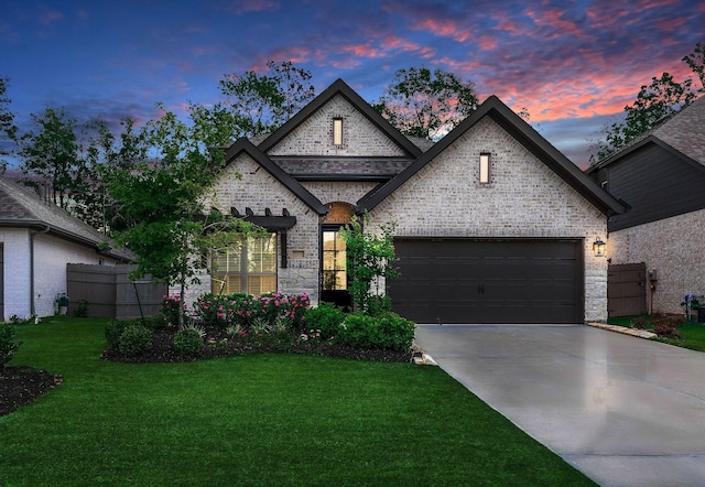 french country inspired facade with a yard and a garage