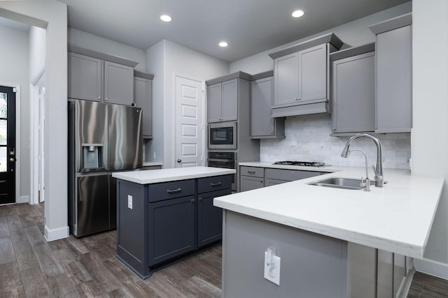 kitchen featuring gray cabinets, a kitchen island, sink, and appliances with stainless steel finishes