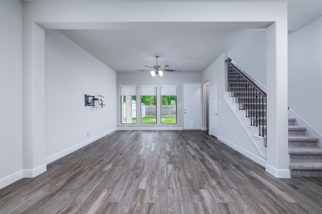 unfurnished living room with ceiling fan and dark wood-type flooring