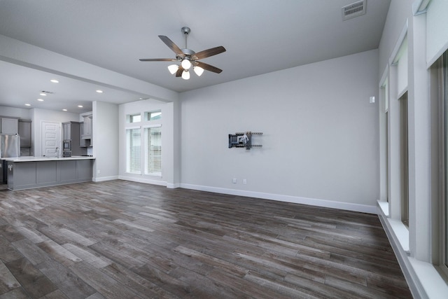 unfurnished living room with ceiling fan, dark hardwood / wood-style flooring, and sink