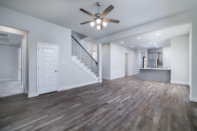 unfurnished living room featuring dark hardwood / wood-style flooring and ceiling fan