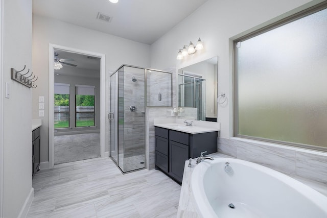 bathroom with plus walk in shower, vanity, and ceiling fan