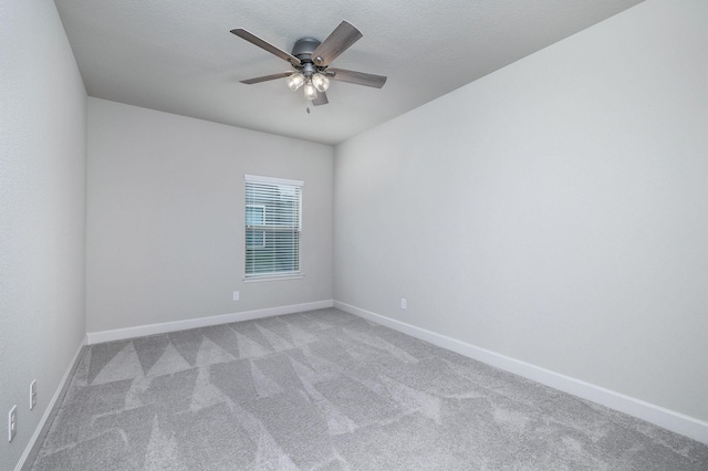 carpeted spare room featuring ceiling fan and a textured ceiling