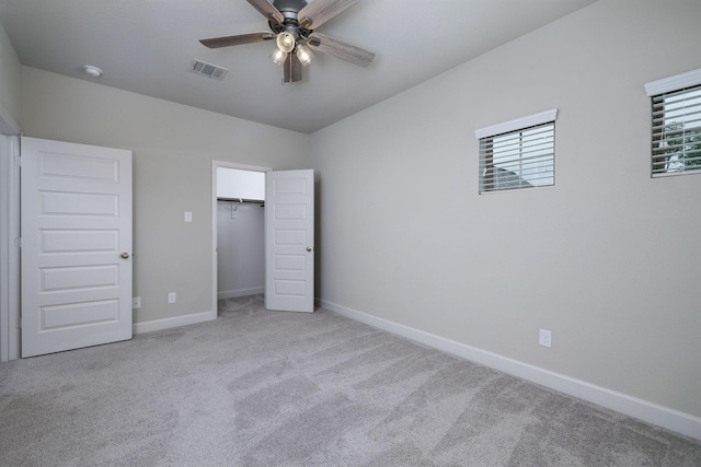 unfurnished bedroom with ceiling fan, light carpet, and a closet