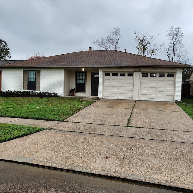 ranch-style house featuring a front lawn and a garage