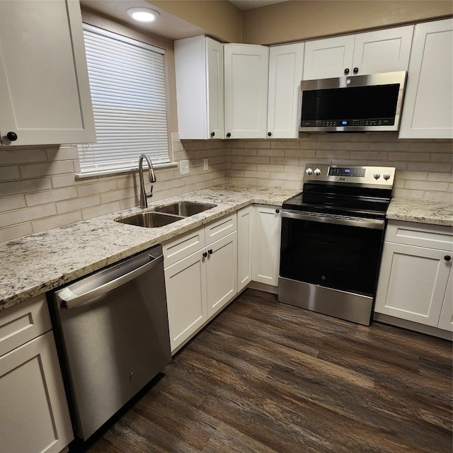 kitchen with decorative backsplash, dark hardwood / wood-style flooring, white cabinetry, appliances with stainless steel finishes, and sink