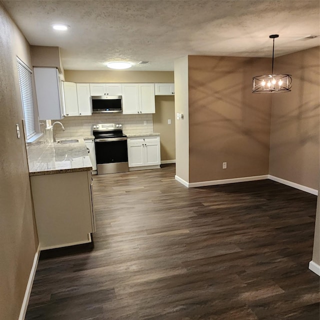 kitchen featuring pendant lighting, backsplash, white cabinetry, appliances with stainless steel finishes, and sink