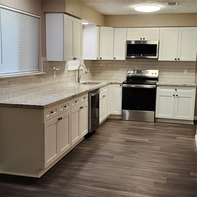 kitchen featuring sink, white cabinetry, dark hardwood / wood-style floors, and appliances with stainless steel finishes