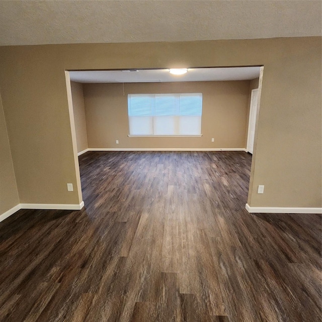 unfurnished room with dark hardwood / wood-style flooring and a textured ceiling