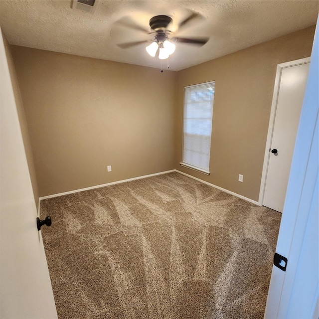 spare room featuring a textured ceiling, ceiling fan, and carpet floors