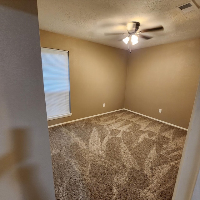 unfurnished room with a textured ceiling, carpet floors, and ceiling fan