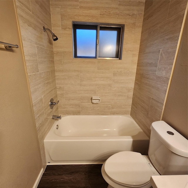 bathroom with toilet and tiled shower / bath