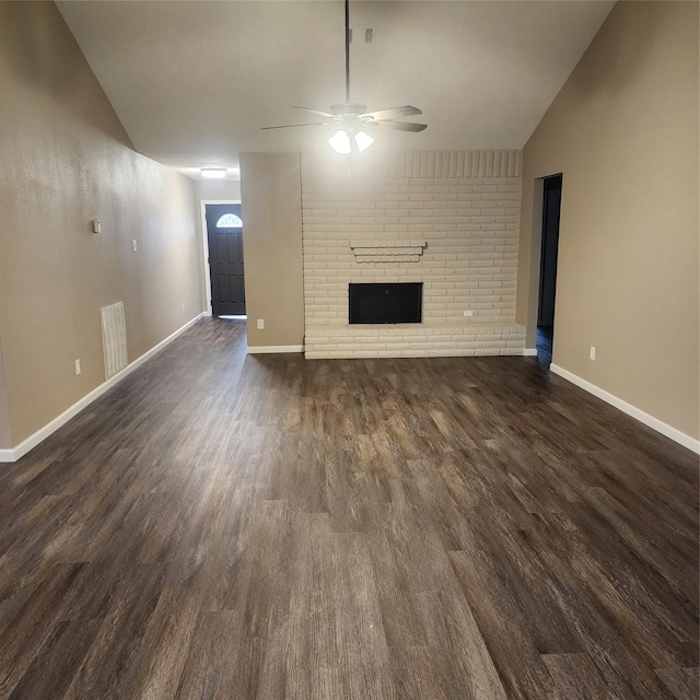 unfurnished living room with ceiling fan, dark hardwood / wood-style flooring, vaulted ceiling, and a fireplace