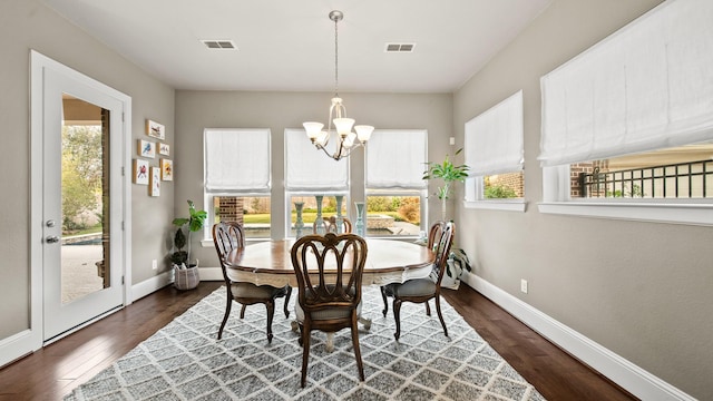 dining area featuring dark wood-type flooring and a chandelier