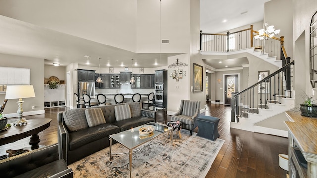 living room with a high ceiling, dark hardwood / wood-style floors, and an inviting chandelier