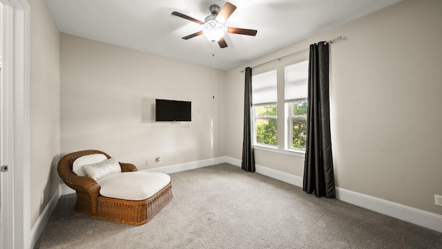 living area featuring ceiling fan and carpet