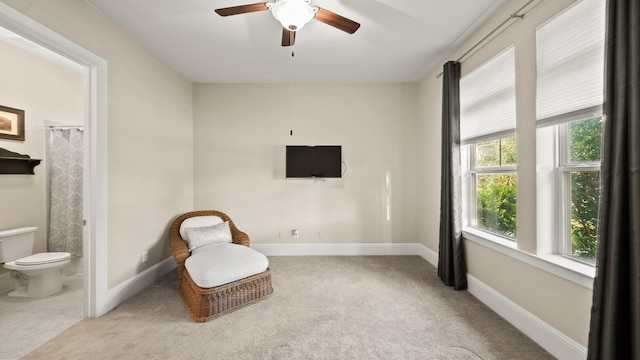 living area featuring ceiling fan, a healthy amount of sunlight, and light carpet