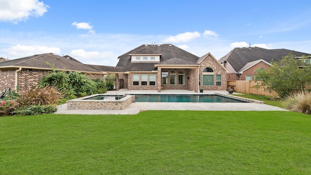 rear view of property featuring a lawn, a pool with hot tub, and a patio area