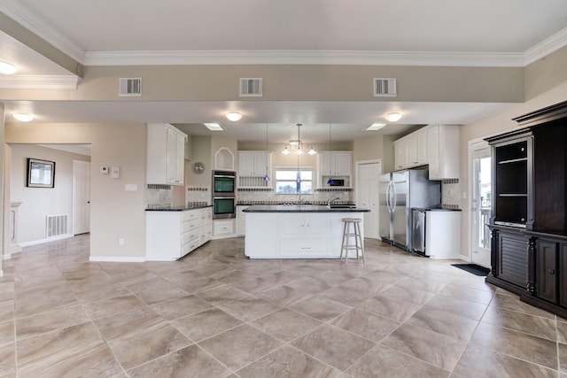 kitchen with white cabinetry, stainless steel appliances, a breakfast bar area, decorative backsplash, and a kitchen island