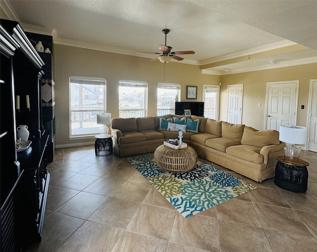 living room with tile patterned flooring, ceiling fan, ornamental molding, and a textured ceiling