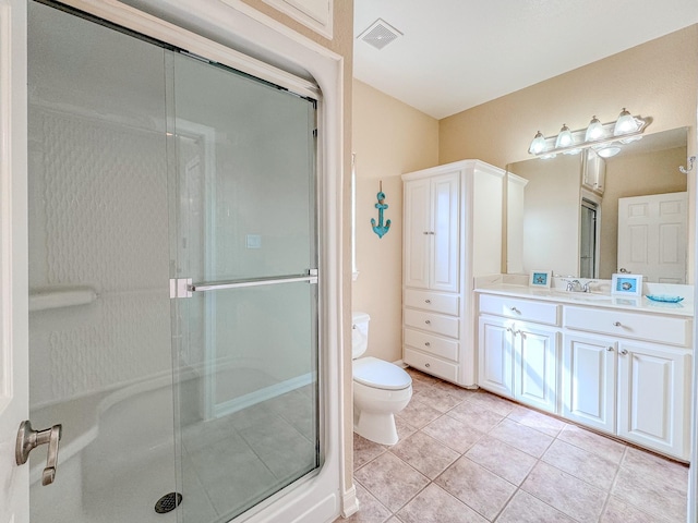 bathroom with tile patterned flooring, vanity, a shower with door, and toilet