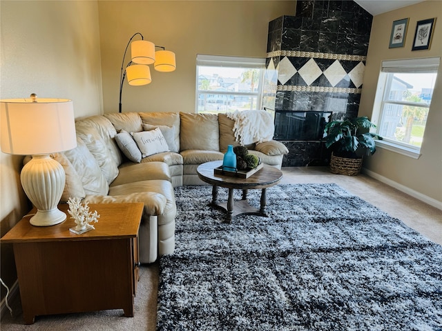 carpeted living room with a high end fireplace