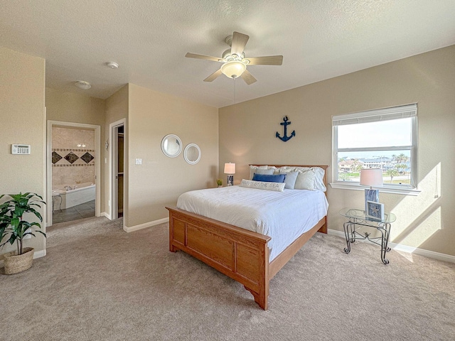 carpeted bedroom with a textured ceiling, ceiling fan, and connected bathroom