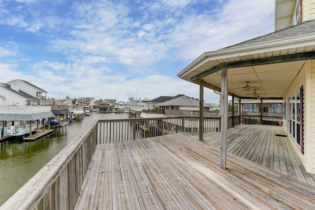 deck with ceiling fan and a water view