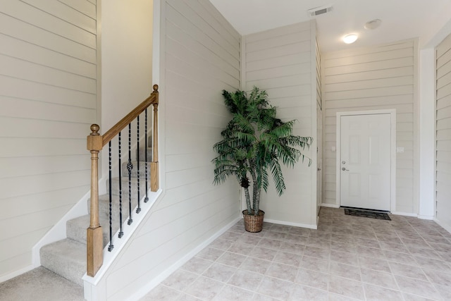 foyer entrance with wooden walls