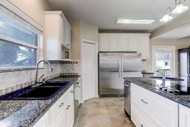 kitchen with pendant lighting, backsplash, white cabinetry, and sink