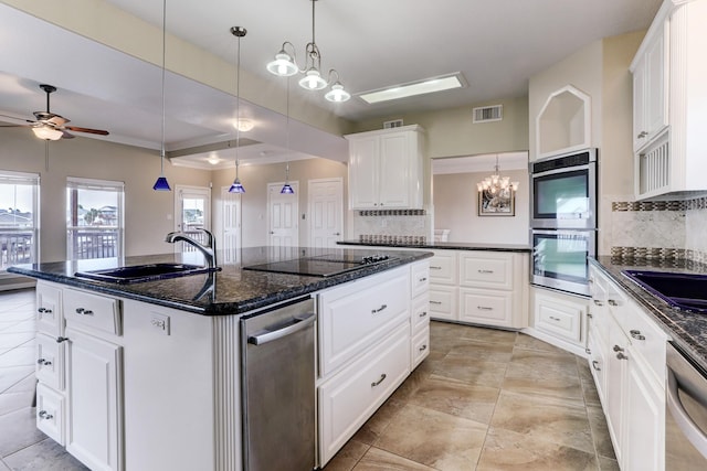 kitchen with backsplash, white cabinetry, a center island with sink, and appliances with stainless steel finishes