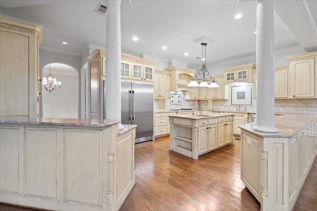 kitchen featuring cream cabinets, ornate columns, a kitchen island, kitchen peninsula, and stainless steel appliances