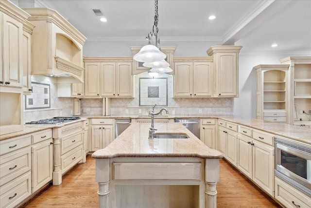 kitchen featuring decorative light fixtures, stainless steel appliances, ornamental molding, and cream cabinets