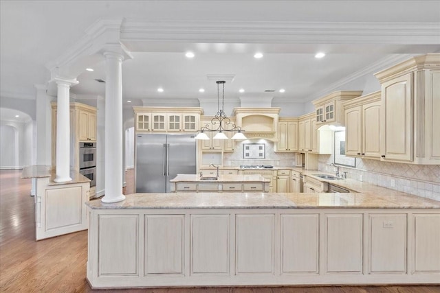 kitchen featuring ornate columns, sink, stainless steel appliances, backsplash, and crown molding