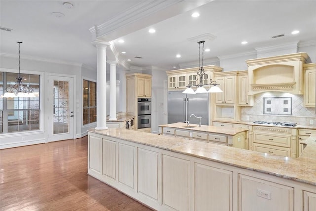 kitchen featuring pendant lighting, decorative backsplash, light stone countertops, ornate columns, and stainless steel appliances