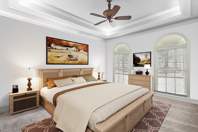 bedroom featuring light carpet, a raised ceiling, and ceiling fan