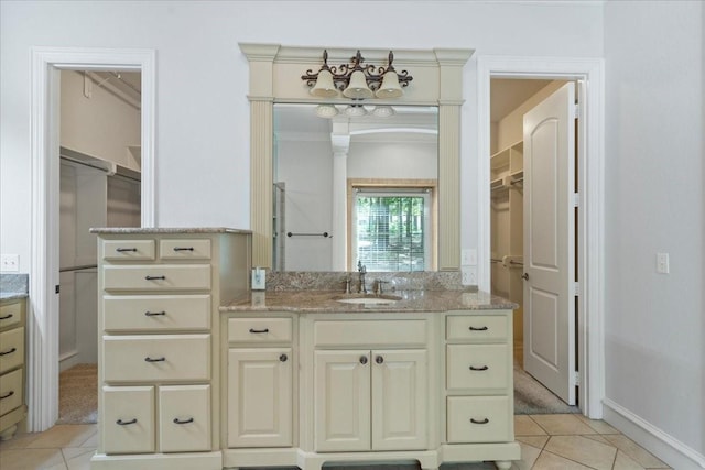 bathroom featuring tile patterned flooring, vanity, and crown molding