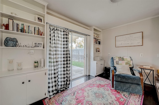 sitting room featuring built in shelves, dark hardwood / wood-style floors, and ornamental molding