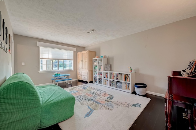 bedroom with dark wood-type flooring and a textured ceiling