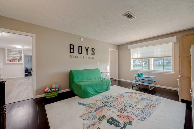 bedroom with a textured ceiling and dark wood-type flooring