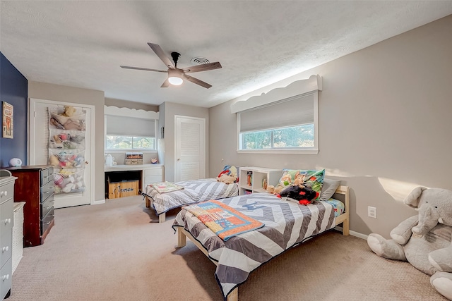 carpeted bedroom with a textured ceiling and ceiling fan