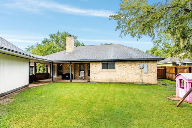 rear view of property with a lawn and a patio