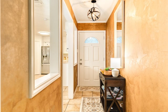 entryway featuring light tile patterned floors, ornamental molding, and a notable chandelier