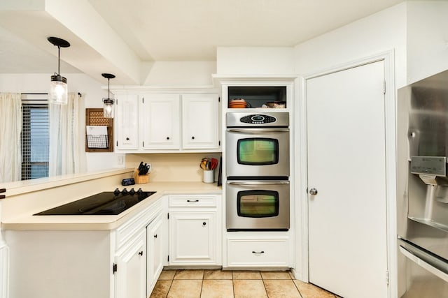 kitchen featuring light tile patterned flooring, white cabinetry, stainless steel appliances, and hanging light fixtures