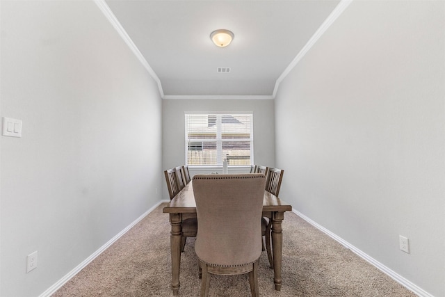 dining room with ornamental molding and carpet floors