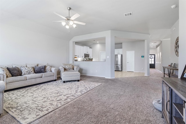 carpeted living room featuring vaulted ceiling and ceiling fan